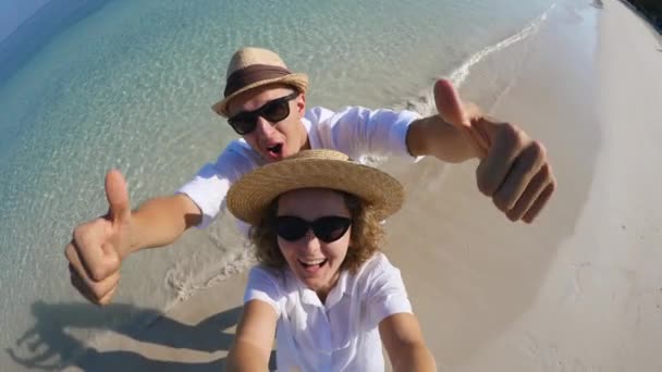 休日のビーチでスマートフォンを使ってセルフィーを撮る幸せな旅行カップル. — ストック動画
