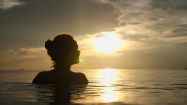 Gün batımında Denizde Yüzen Kadın Silueti