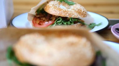 Marul, domates ve kızarmış hindistancevizli vejetaryen simit.