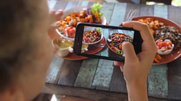 Feminino Food Blogger tirar foto de alimentos saudáveis usando Smartphone no restaurante — Vídeo de Stock