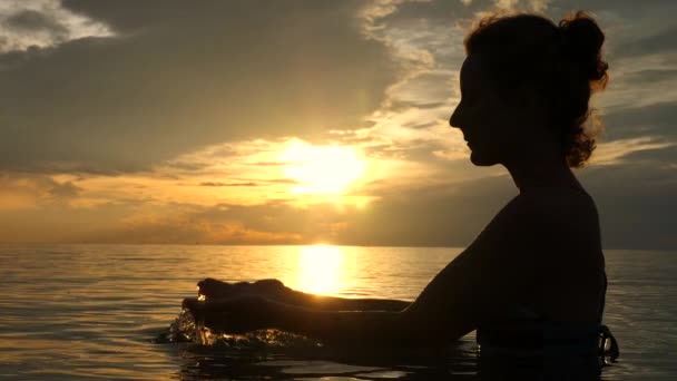 Силуэт женщины, наслаждающейся морем и закатом — стоковое видео