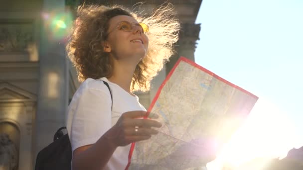 Turista mulher segurando viajante mapa na cidade ao pôr do sol — Vídeo de Stock