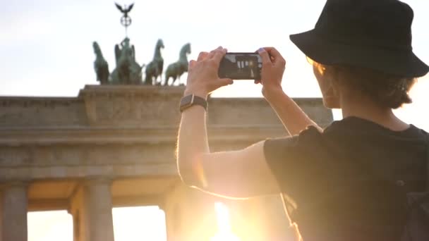 Mulher viajante tirando foto da famosa atração turística com celular ao pôr do sol — Vídeo de Stock