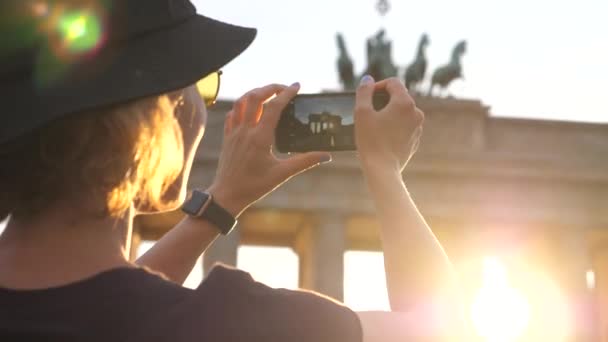 Reiziger toeristische vrouw neemt foto van oriëntatiepunt met smartphone bij zonsondergang — Stockvideo