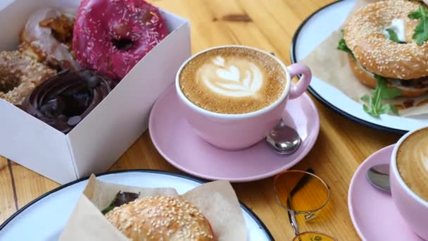 Frühstück mit Kaffee, Bagels und Donuts. stylische trendige Sommerkomposition. — Stockvideo