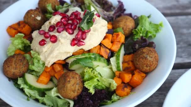 Υγιεινή διατροφική έννοια. Κλείσιμο των χορτοφαγικών σαλάτας με Falafel, Hummus, Bulgur και Avocado. — Αρχείο Βίντεο