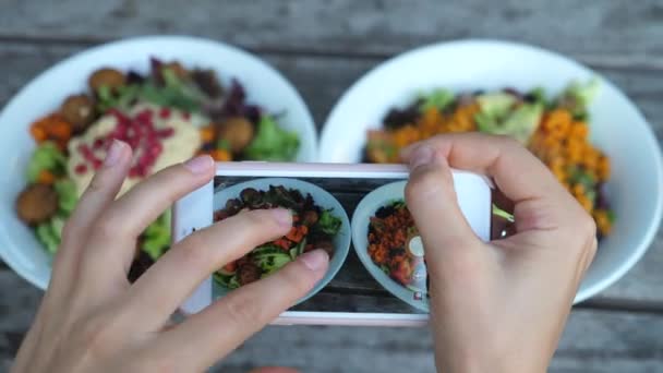 Закройте руки, фотографируя еду в кафе, сосредоточьтесь на салатных чашах на экране — стоковое видео