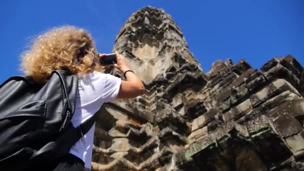 Turista femenina con Smartphone tomando fotos de Angkor Antiguo Templo — Vídeo de stock