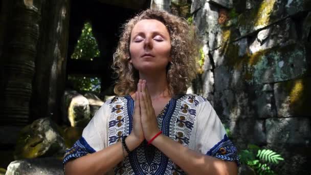 Молодая женщина в племенном платье практикует йогу в мистическом лесу — стоковое видео
