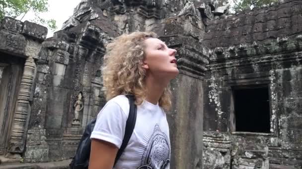 Jonge vrouw toeristische bezienswaardigheden in de oude tempel van Angkor — Stockvideo