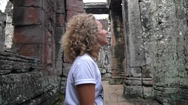Vrouwelijke toeristische bezienswaardigheden in de oude Angkor Wat Tempel — Stockvideo