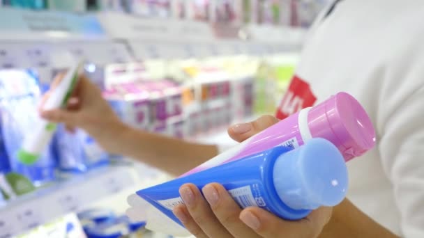 Mujer Elegir productos de cuidado de belleza durante las compras en la tienda de cosméticos — Vídeos de Stock