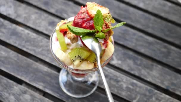 Mangiare gelato Sundae Dessert con cucchiaio sulla tavola di legno — Video Stock