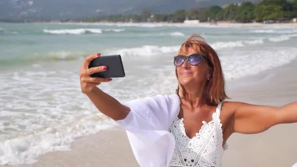 Anziana donna prendendo selfie con smartphone su il spiaggia — Video Stock