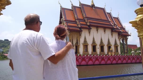 Idősebb pár turisták nyaralás, hogy városnézés a buddhista templom. — Stock videók