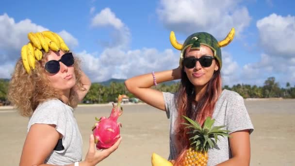Две забавные многорасовые девушки развлекаются на летнем пляже — стоковое видео