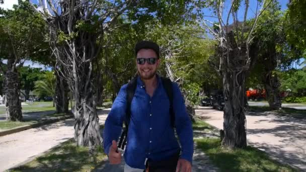 Knappe jongeman met rugzak toont duimen omhoog in reizen — Stockvideo