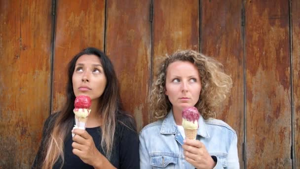 Dos mujeres jóvenes de raza mixta con helado se divierten en verano — Vídeos de Stock