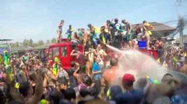 Songkran Festivali. Çılgın kalabalıkla dolu bir itfaiye aracı. Sokaktaki Su Dövüşü.