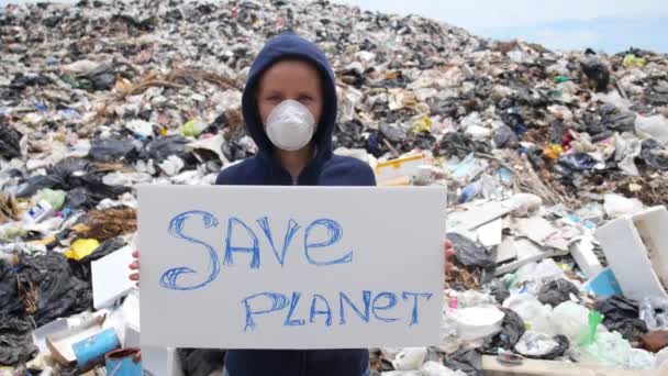 Женщина в маске призывает спасти планету на свалке отходов — стоковое видео