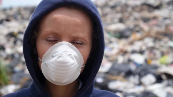 Vrouw met masker kijkt in de camera op vuilnisbelt. Vervuiling, ecologische ramp — Stockvideo