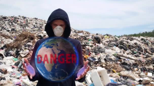 Człowiek z hologramem Planeta Ziemia w śmieciach. Zanieczyszczenia — Wideo stockowe