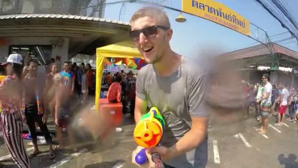 Veselý muž střelec s vodní pistolí na ulici slaví Songkran. Pomalý pohyb. — Stock video