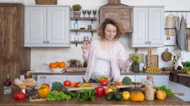 Mutfakta sağlıklı salata yapan mutlu hamile kadın..
