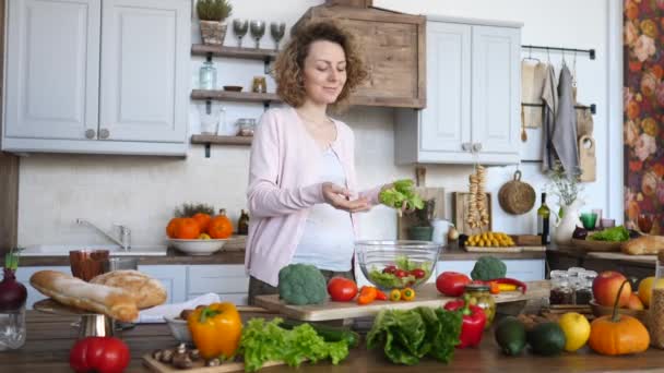 Terhes fiatal nő főzés egészséges élelmiszer - Zöldségsaláta. Diéta és fogyókúra koncepció. Egészséges életmód. Főzés otthon. — Stock videók