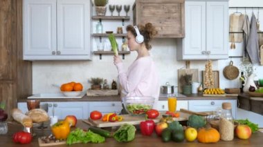Genç Hamile Kadın Mutfakta Dans Ederken Sağlıklı Organik Vegan Yemekler Pişiriyor.