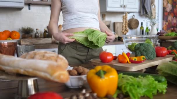 Närbild av mage av gravida kvinna med grön sallad. Hälsosam kost under graviditet. — Stockvideo