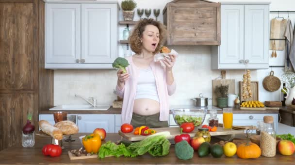 Comida chatarra vs comida saludable. Mujer embarazada sosteniendo hamburguesa y brócoli decidiendo qué comer . — Vídeo de stock