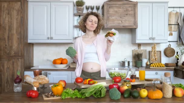 Portré a terhes nőről ócska kajával és egészséges kajával. — Stock videók