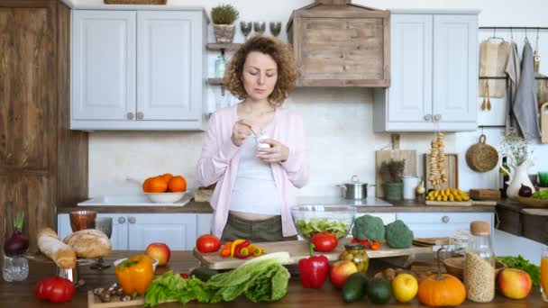 Mujer embarazada comiendo yogur en la cocina. Concepto de comida saludable . — Vídeo de stock