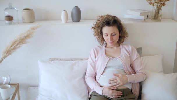 Concepto de embarazo. Embarazada hembra descansando en casa en cama . — Vídeos de Stock