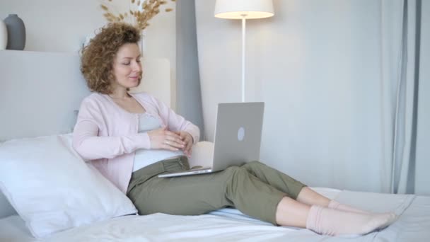 Zwangere vrouw werken op laptop thuis — Stockvideo