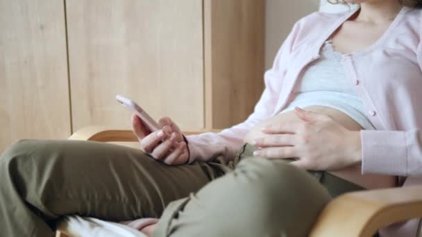 Ciąża, ludzie i koncepcja technologii. Kobieta w ciąży za pomocą smartfona. — Wideo stockowe