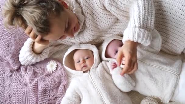 Jovem mãe deitada com seu bebê pequeno gêmeos — Vídeo de Stock