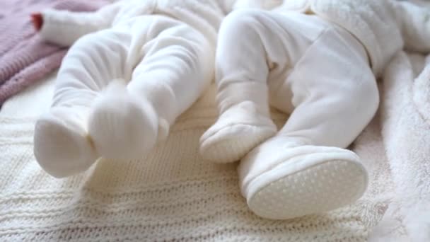 Close-up van baby tweeling benen in pluche schoenen — Stockvideo