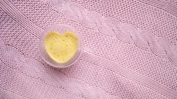 Trendy Golden Latte With Turmeric In Heart-Shaped Glass Cup. Closeup. — 비디오