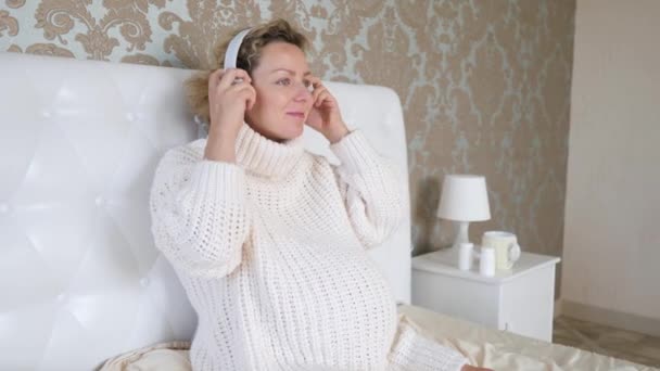Hamilelik sırasında müzik dinleme kavramı. Kulaklıklı Hamile Kadın. — Stok video