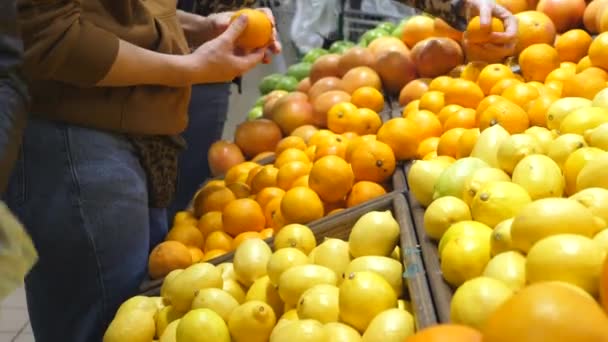 Kobieta podnoszenia Pomarańczowy w supermarkecie. — Wideo stockowe