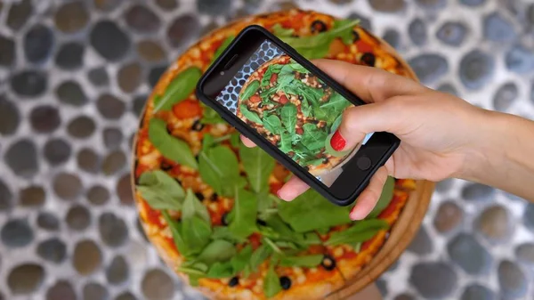 Kvinnlig hand tar bild av Pizza med smartphone. — Stockfoto