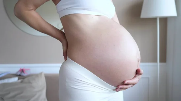 Gravid kvinna som lider av ryggvärk. Närbild av Belly. — Stockfoto