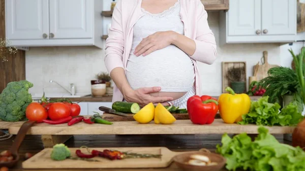 Terhes nő főzés egészséges ételek otthon a konyhában. — Stock Fotó