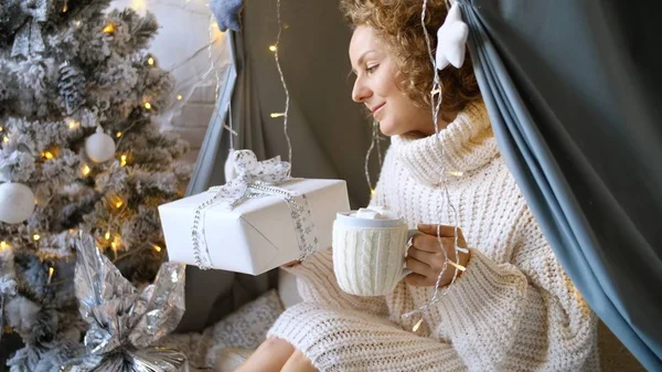 Щаслива жінка тримає гарячий шоколад з зефіром та різдвяними подарунками — стокове фото