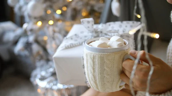 Female Hand Holding Christmas Gift Box And Cup of Hot Chocolate with Marshmallow — стокове фото