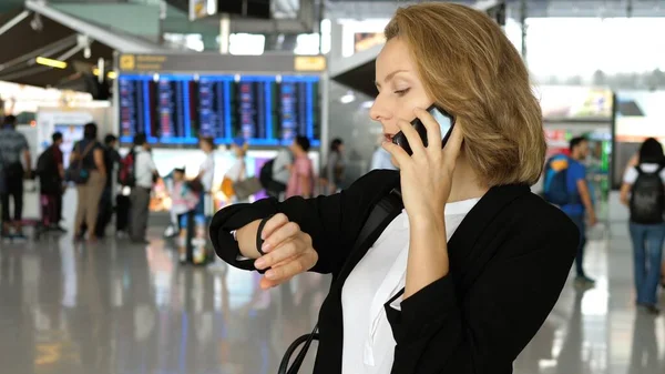 Молода бізнес-леді в діловій поїздці Виступаючи на смартфоні в аеропорту — стокове фото