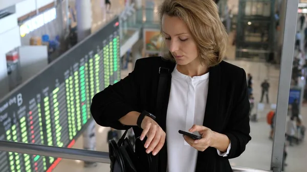 Mulher de negócios verificando o tempo no Smartwatch no aeroporto . — Fotografia de Stock