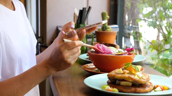 Vrouw voedsel blogger met behulp van smartphone nemen van foto van voedsel in Cafe — Stockfoto